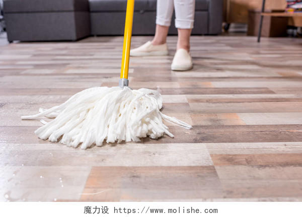 女人用拖把清洁地板摄影图